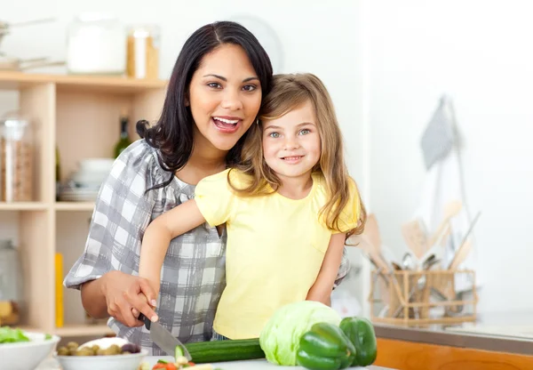 Sorrindo mãe e filha cortando legumes juntos — Fotografia de Stock