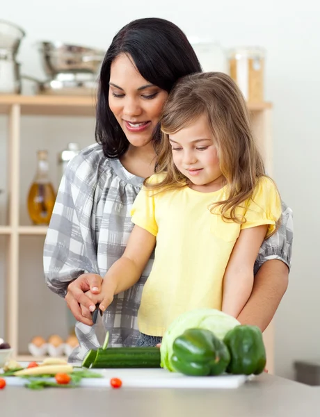 Bela mãe ajudando sua filha a cortar legumes — Fotografia de Stock