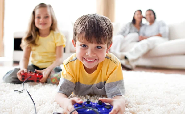 Ładny mały chłopiec gra wideo gra z siostrą — Zdjęcie stockowe