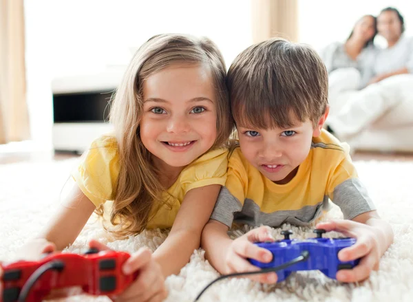 Χαριτωμένο μικρό αγόρι που παίζει βίντεο παιχνίδι με την αδελφή του — Stock fotografie