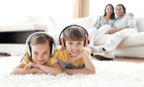 Adorables hermanos escuchando música con auriculares —  Fotos de Stock
