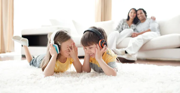Niños riéndose escuchando música con auriculares —  Fotos de Stock