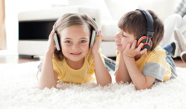 Παιδιά που παίζουν στο πάτωμα με τα ακουστικά — Φωτογραφία Αρχείου