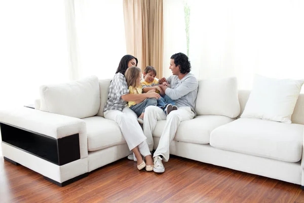 Família animada se divertindo sentada no sofá — Fotografia de Stock