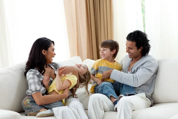 Ouvir os pais brincando com seus filhos no sofá — Fotografia de Stock