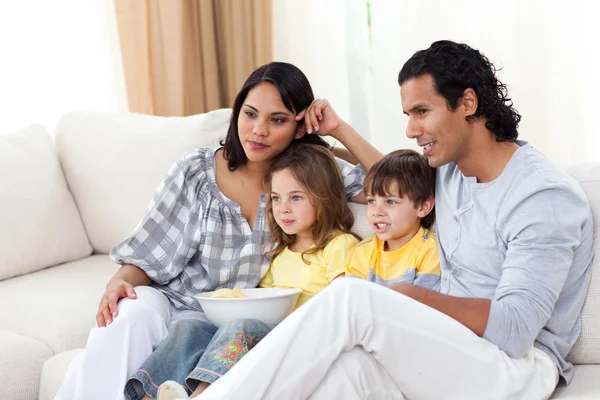 Felice famiglia guardando la TV sul divano — Foto Stock