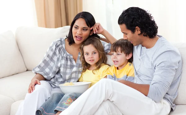 Jollyfamily sledování televize na pohovce — Stock fotografie