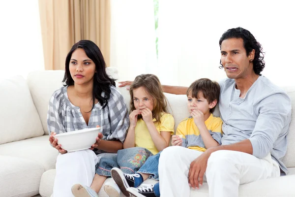 Famiglia concentrata a guardare la TV sul divano — Foto Stock