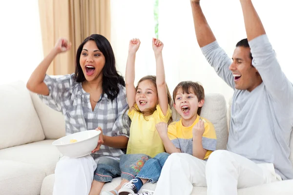 Familia animada viendo televisión en el sofá — Foto de Stock