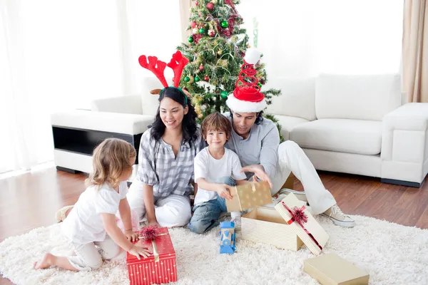 Lycklig familj öppnar jul presenterar — Stockfoto