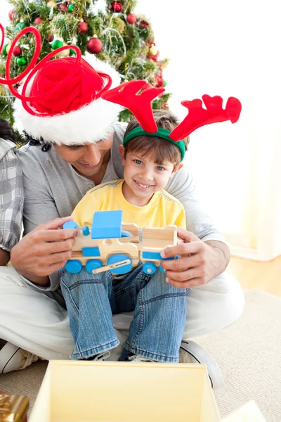 Happy child playing with a train with his father — Stock Photo, Image