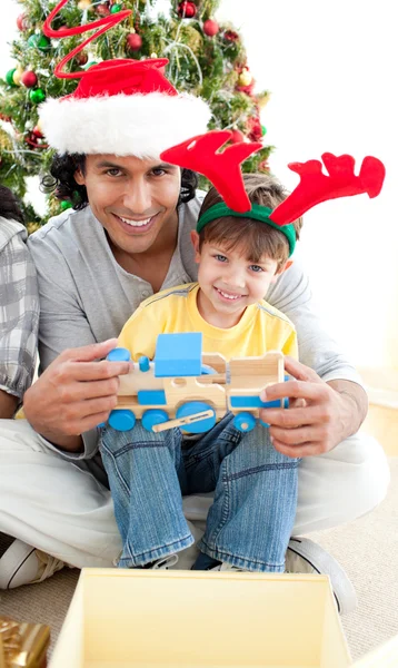 Pai e filho brincando com um presente de Natal — Fotografia de Stock