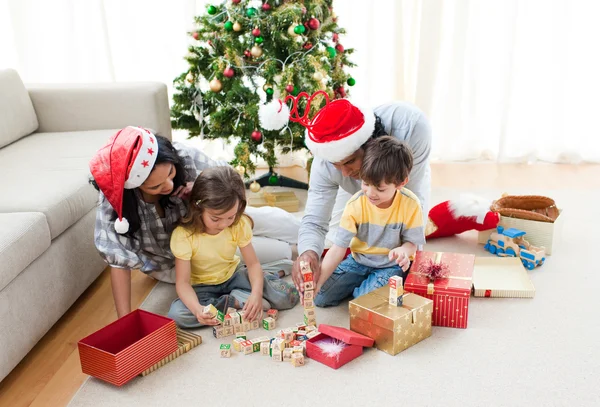 Família brincando com presentes de Natal em casa — Fotografia de Stock