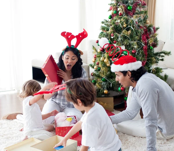 Ευτυχισμένη οικογένεια άνοιγμα των χριστουγεννιάτικων παρουσιάζει — Φωτογραφία Αρχείου