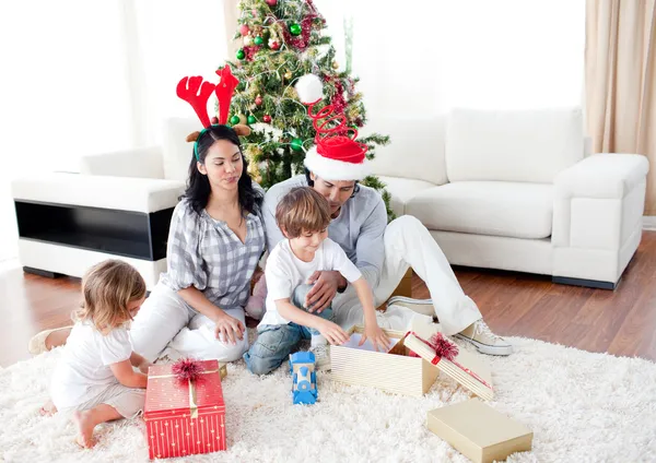 Família feliz abrindo presentes de Natal — Fotografia de Stock
