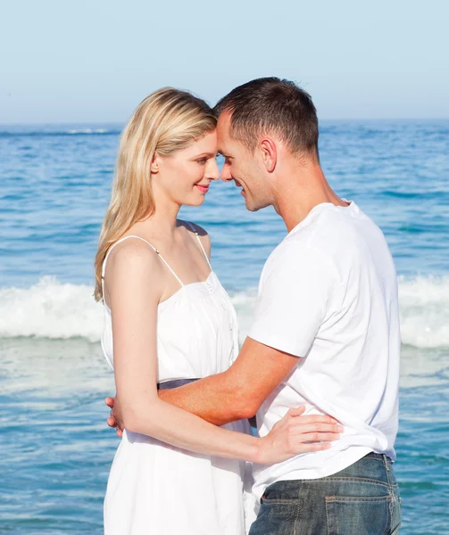 Älskande par krama på stranden — Stockfoto