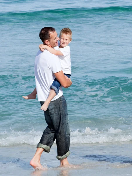 Menino bonito e seu pai andando na areia — Fotografia de Stock