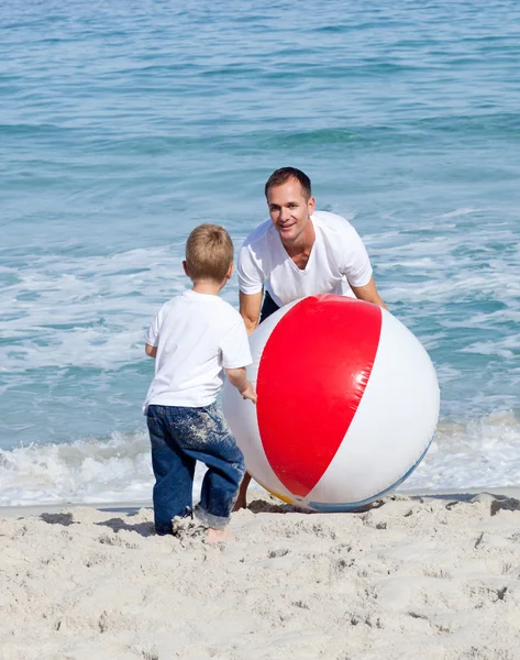 Pai alegre e seu filho brincando com uma bola — Fotografia de Stock