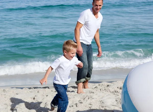 Pai animado e seu filho brincando com uma bola — Fotografia de Stock