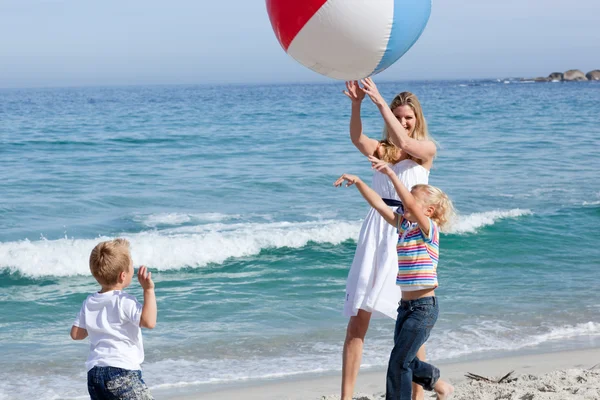 Feliz madre y sus hijos jugando con una pelota — Foto de Stock