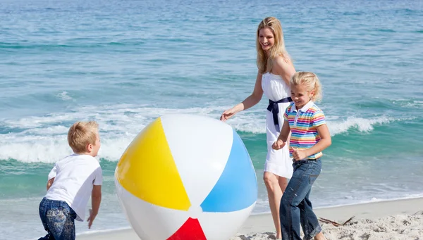 Mãe alegre e seus filhos brincando com uma bola — Fotografia de Stock