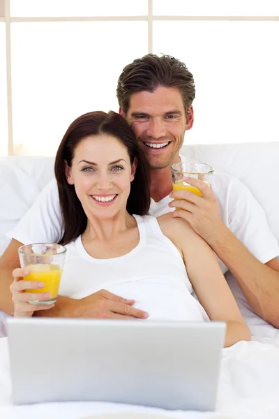 Sorridente coppia bere succo d'arancia — Foto Stock