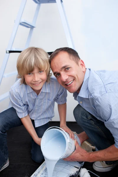 Портрет улыбающегося отца и его сына, готовящего краску — стоковое фото