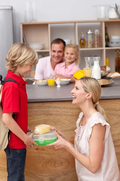 Zorgzame moeder verpakking de school lunch aan zijn zoon — Stockfoto