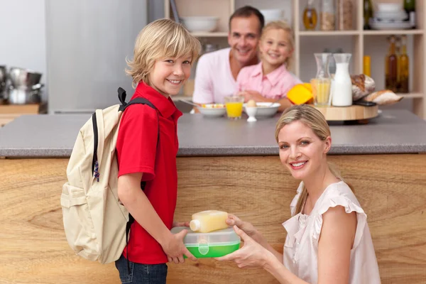 Attentive mother packing the school lunch to his son — Stock Photo, Image