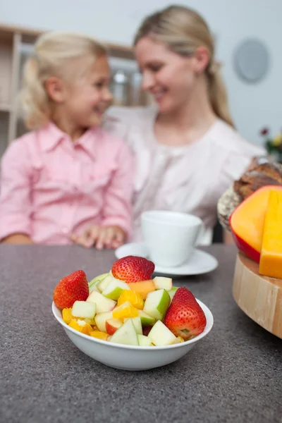 Niña rubia comiendo fresa con su madre —  Fotos de Stock