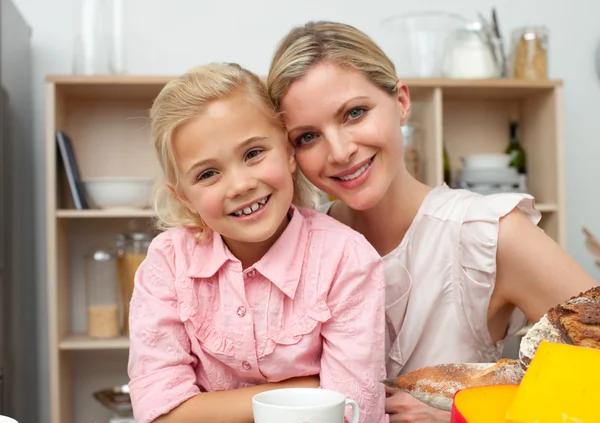 Jolly little girl eating fruit with her mother — Stock Photo, Image