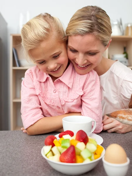 Adorable little girl eating fruit with her mother — Stock Photo, Image