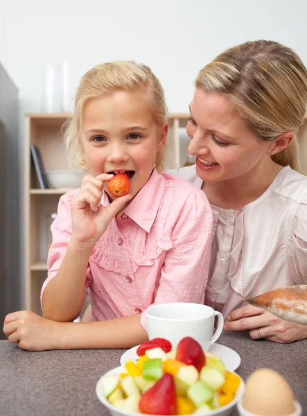 Attraktiva mamma äta frukt med dottern — Stockfoto