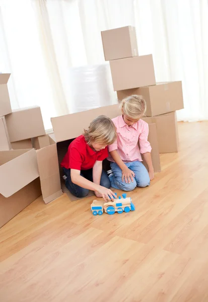 Adorable sibling playing with a train — Stock Photo, Image