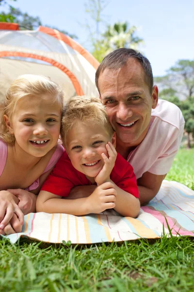 Glücklicher Vater und seine Kinder im Gras liegend — Stockfoto