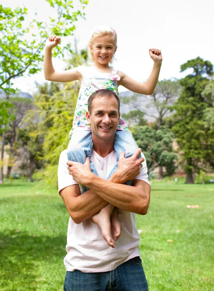 Веселый отец катает свою дочь на спине — стоковое фото