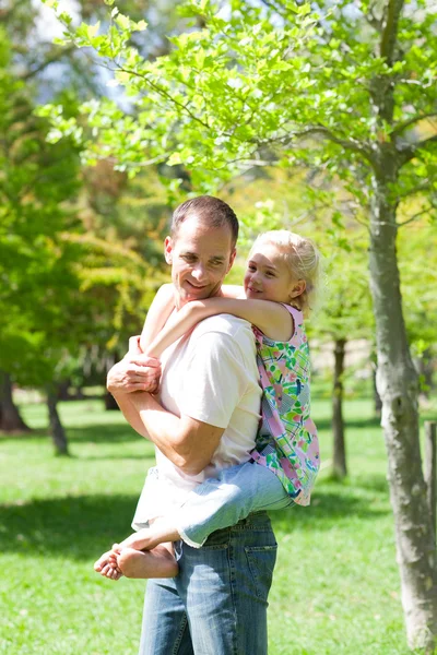 Lively father giving his daughter piggy-back ride — Stock Photo, Image