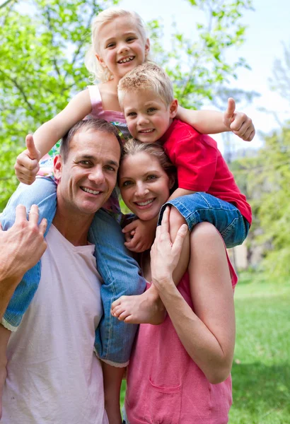 Smiling parents giving their children piggy-back ride — Stock Photo, Image