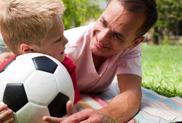 Close-up de um pai atencioso e seu filho segurando um bal de futebol — Fotografia de Stock