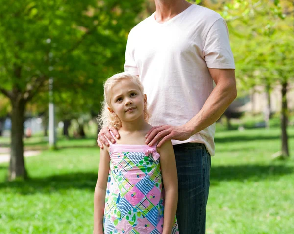 Söt liten flicka med sin far i en park — Stockfoto
