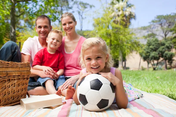 Kleines blondes Mädchen mit einem Fußballball bei einem Picknick — Stockfoto