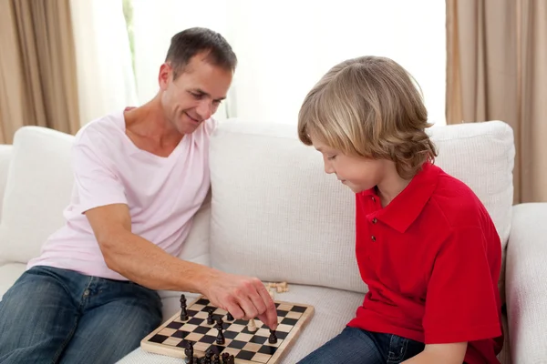 Attentive father playing chess with his son — Stock Photo, Image