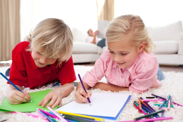 Concentrated children drawing lying on the floor — Stock Photo, Image