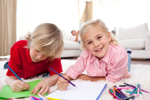 Cheerful children drawing lying on the floor — Stock Photo, Image