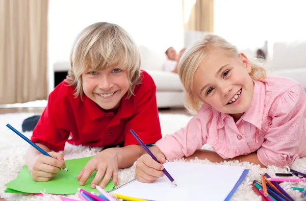 Smiling children drawing lying on the floor — Stock Photo, Image