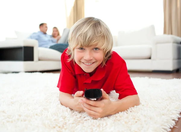 Lächelnder Junge vor dem Fernseher, der auf dem Boden liegt — Stockfoto