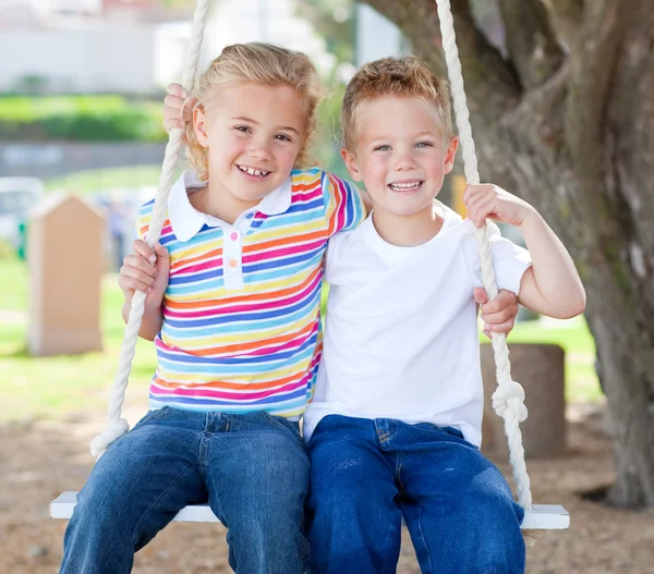 Cute siblings swinging — Stock Photo, Image