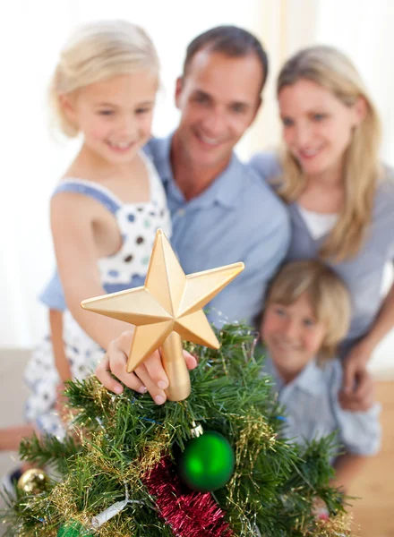 Pai levantando sua filha para colocar a estrela de Natal em cima de — Fotografia de Stock