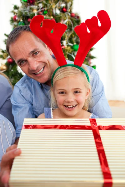 Портрет улыбающегося отца и его дочери, открывающего Рождество — стоковое фото