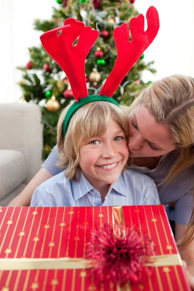 Liefhebbende moeder kussen zoon met Kerstmis — Stockfoto